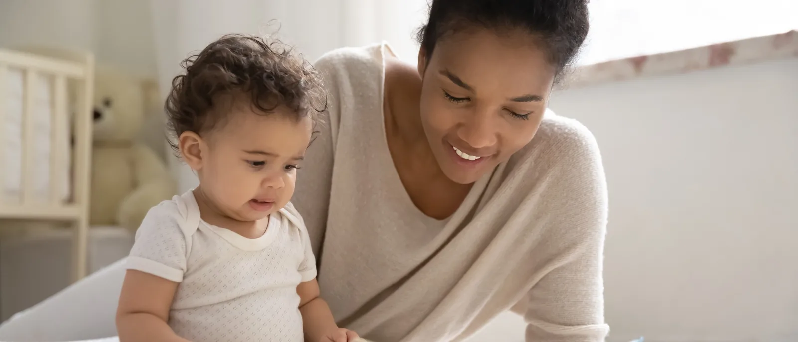 Mãe e bebê lendo um livro juntos no chão